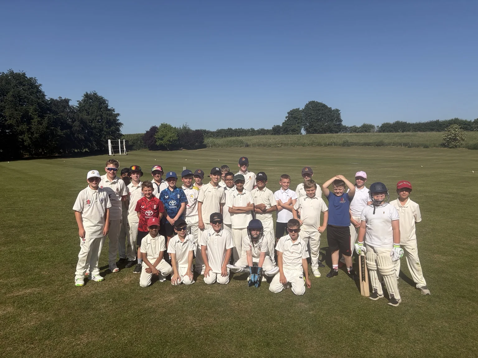 A large DG Cricket group together on a sunny cricket ground